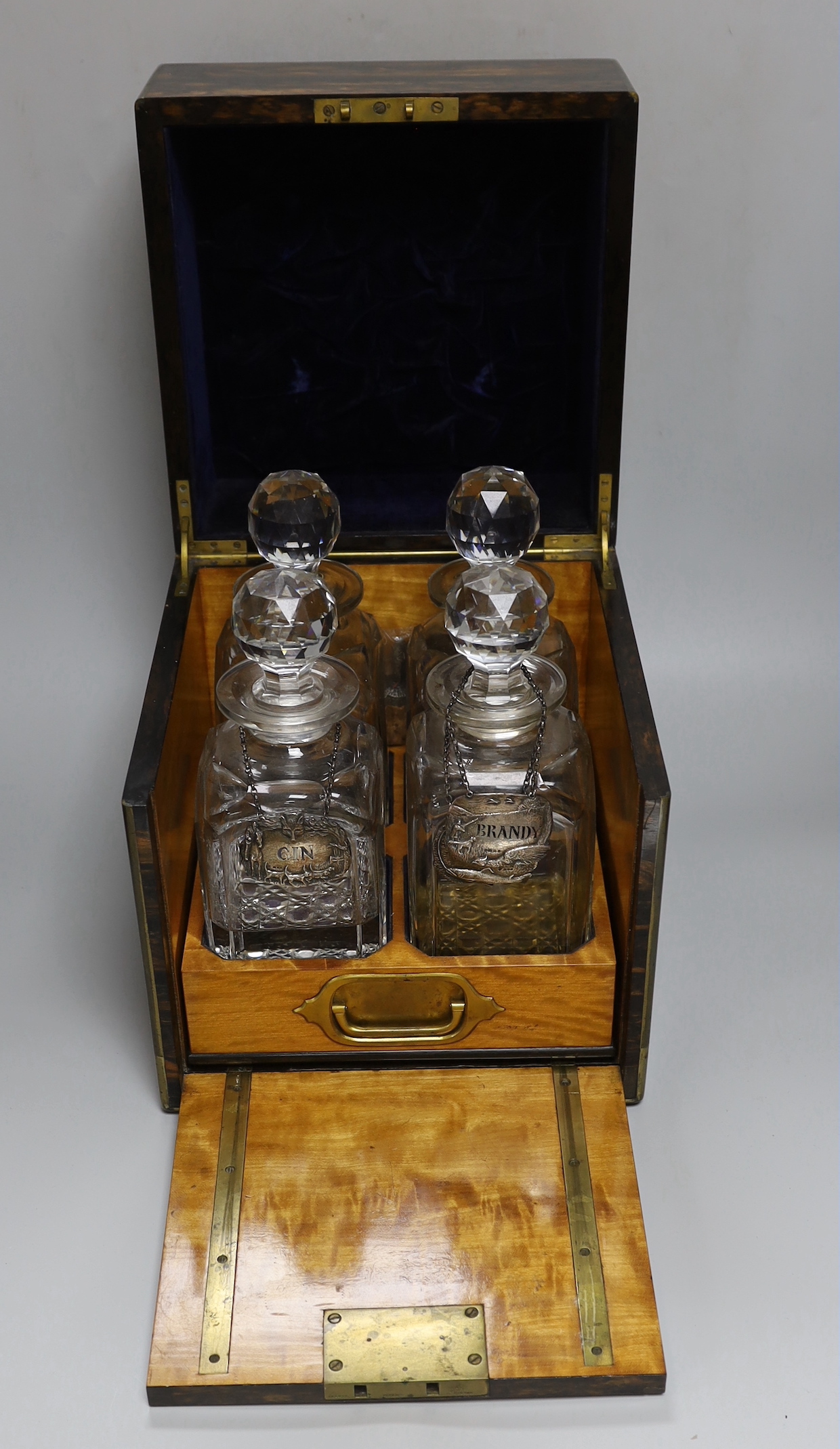 A Victorian coromandel four bottle decanter box with Bramah lock, three silver ‘hunting’ spirit labels and another enamelled, height of box 30cm
